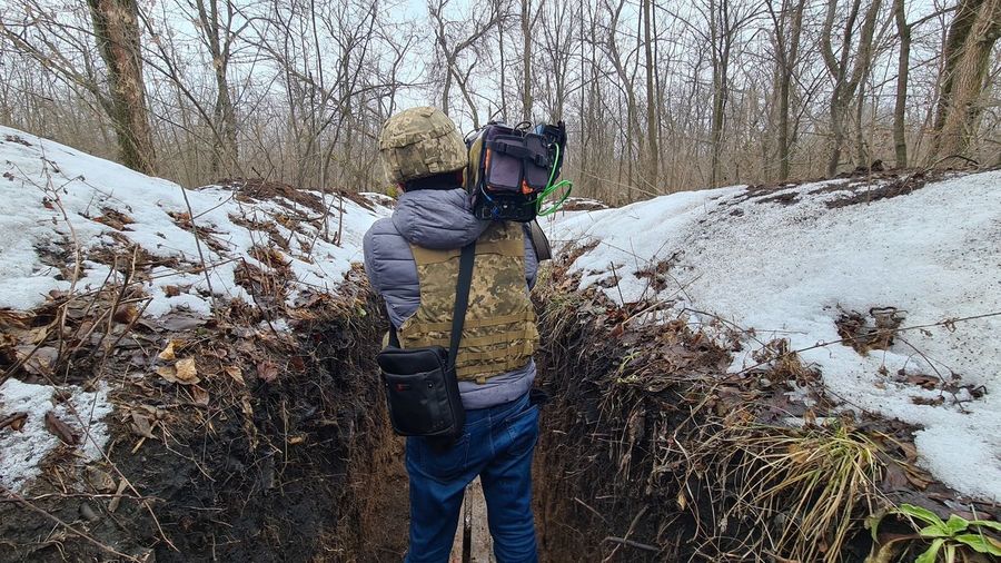 Camera operator working at donetsk, luhansk region of ukraine into trench warfare