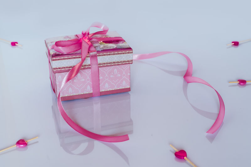 Close-up of pink box on table against white background