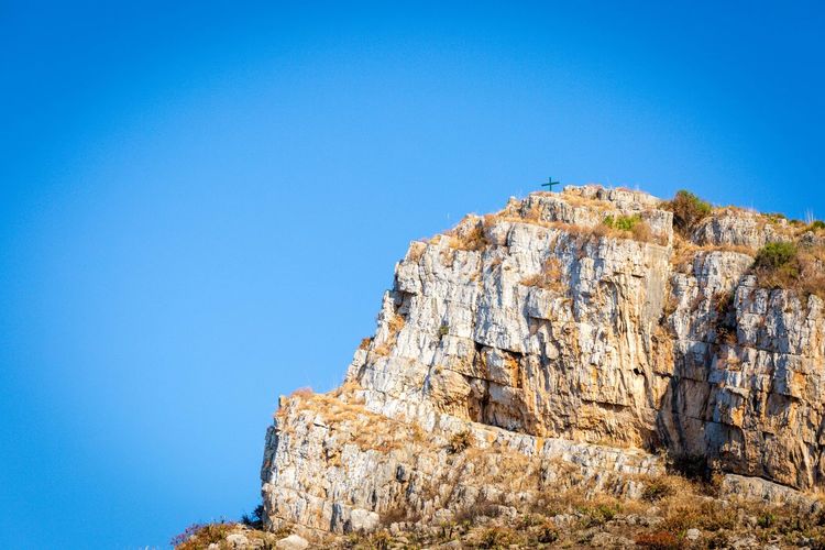 View of cliff against clear blue sky