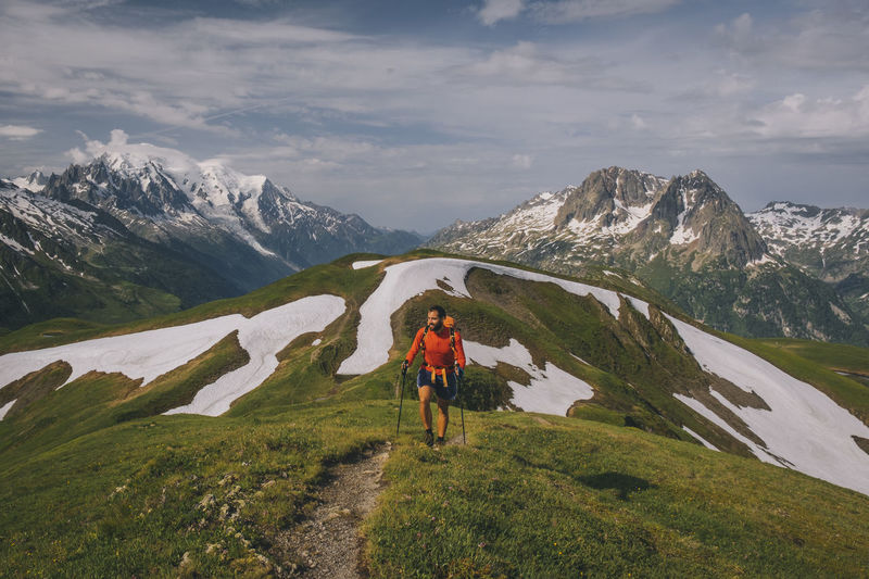 Young male hikes in the french alps with mont blanc as a backdrop.