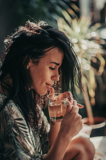Portrait of a young woman drinking water