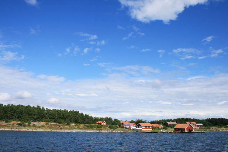 Houses by lake against sky
