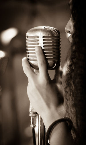 Close-up of woman singing over microphone
