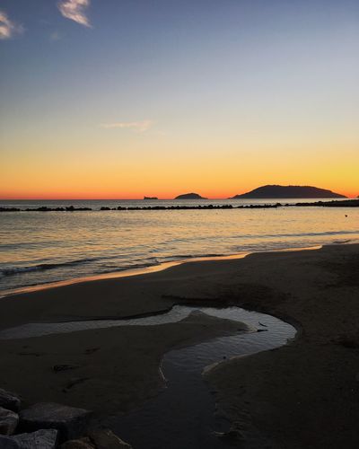 Scenic view of beach against sky during sunset