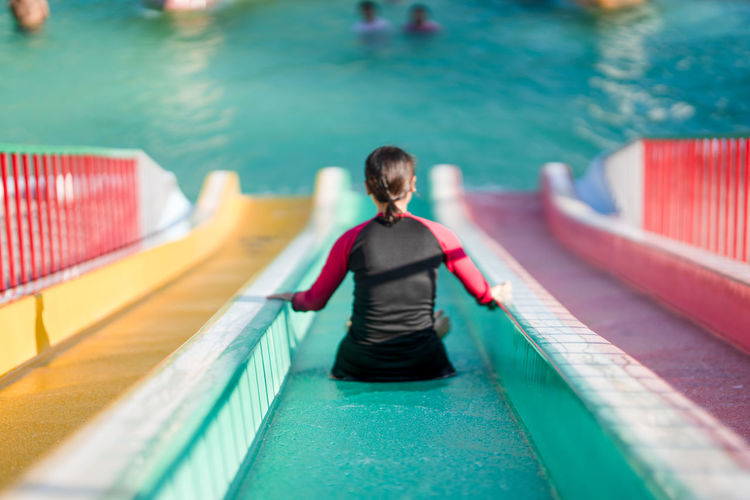 Rear view of woman sliding in water park