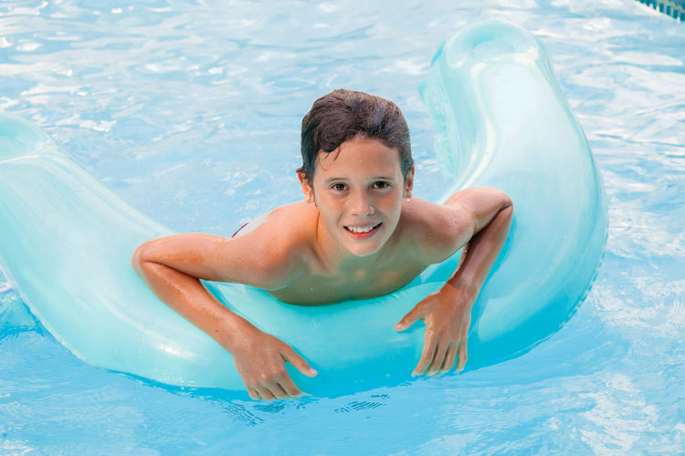 Portrait of happy boy swimming in pool