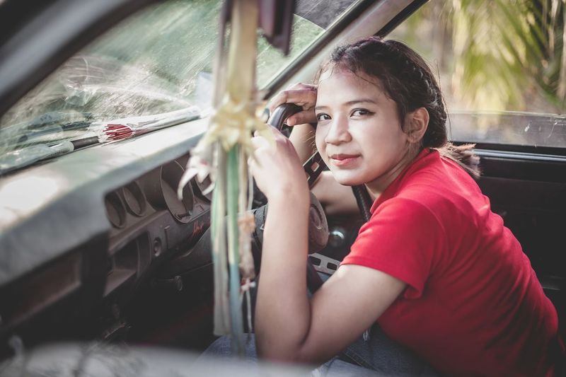 Portrait of young beautiful women driving a car.