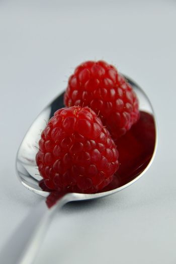 Close-up of raspberries on white background