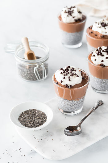 Above view of chocolate mousse chia pudding parfaits with chia seeds in front.