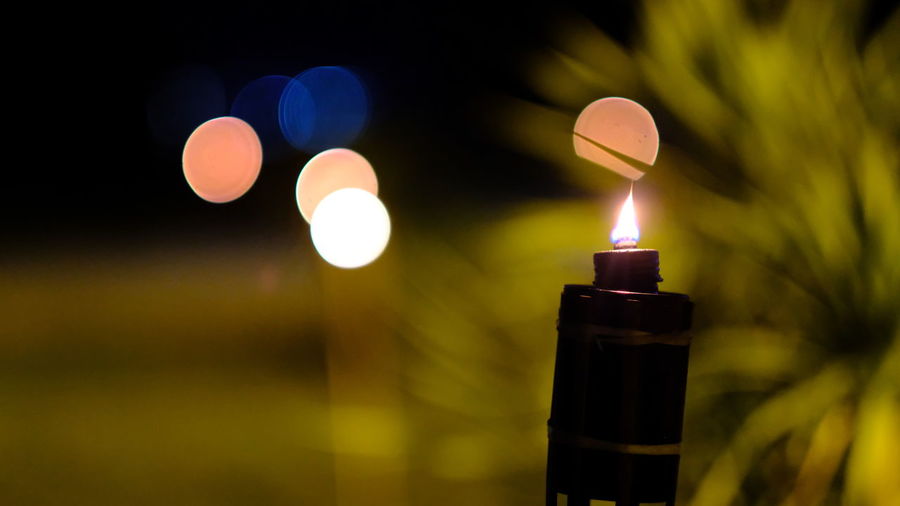 Close-up of lit candle against blurred background