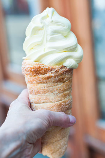 Close-up of human hand holding ice cream cone outdoors