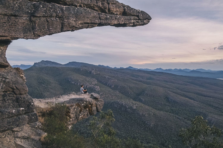 Woman sits at the balconies and looks the landscape of the grampians national park, victoria, australia
