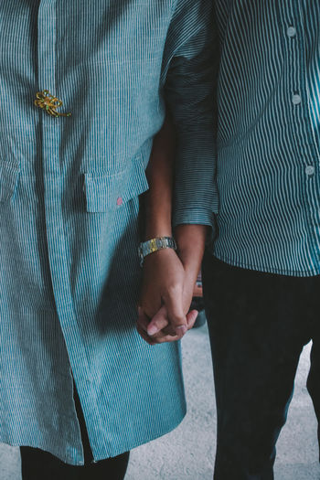 Midsection of couple holding hands