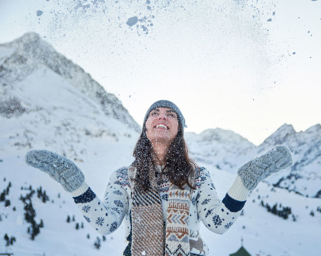 Winter portrait of a young woman, snow, mountain, outdoors, happy