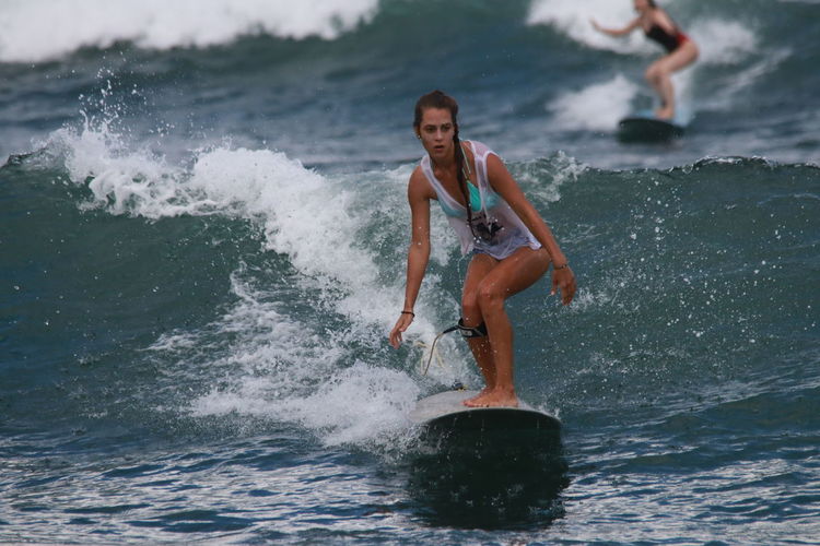 Young woman surfing on sea