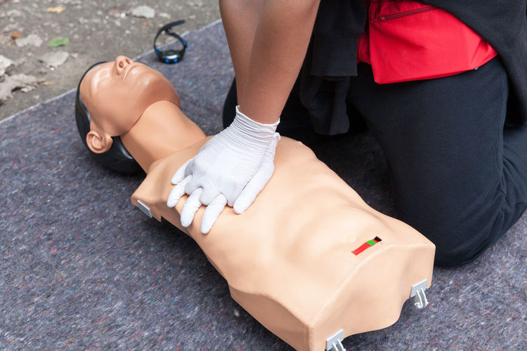 Low section of person performing cpr on dummy