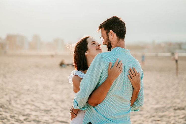 Couple embracing while standing on beach