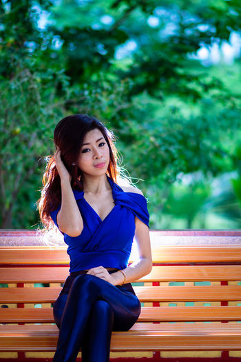 Portrait of young woman sitting on bench