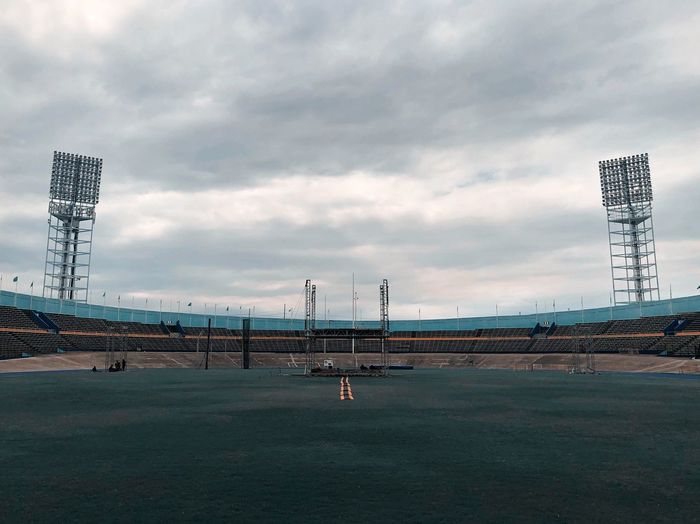 Stadium against cloudy sky in city