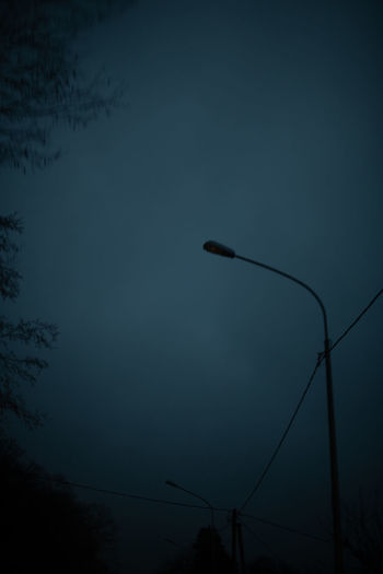 Low angle view of silhouette street light against sky at dusk