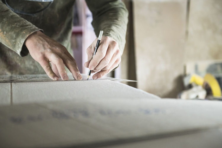 Surfboard shaper measuring a new design
