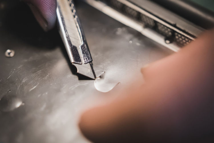 Close-up of person working on metal