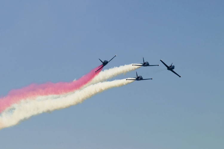 A formation of four jets in the patriots flying team as they perform a high-speed maneuver.