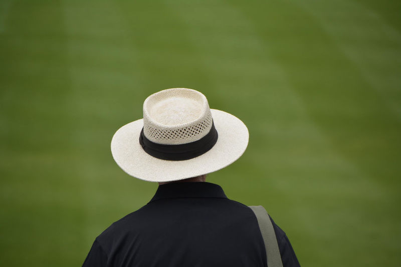 Rear view of man wearing straw hat on field