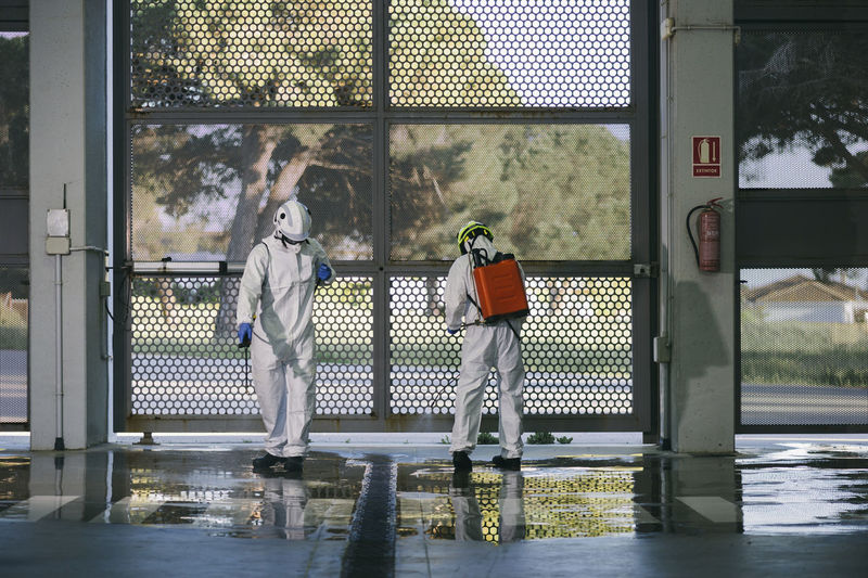Two firefighters disinfecting the interior of a building