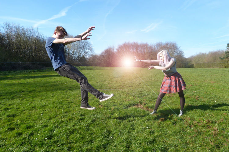Full length of girl jumping on grassy field