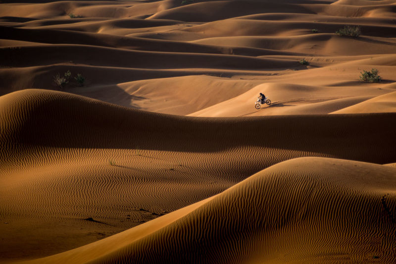 High angle view of man riding motorcycle on sand at desert