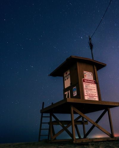 Low angle view of lifeguard hut against star field