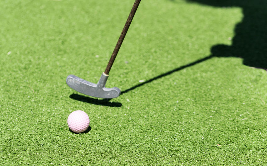 Close-up of golf club with ball on ground