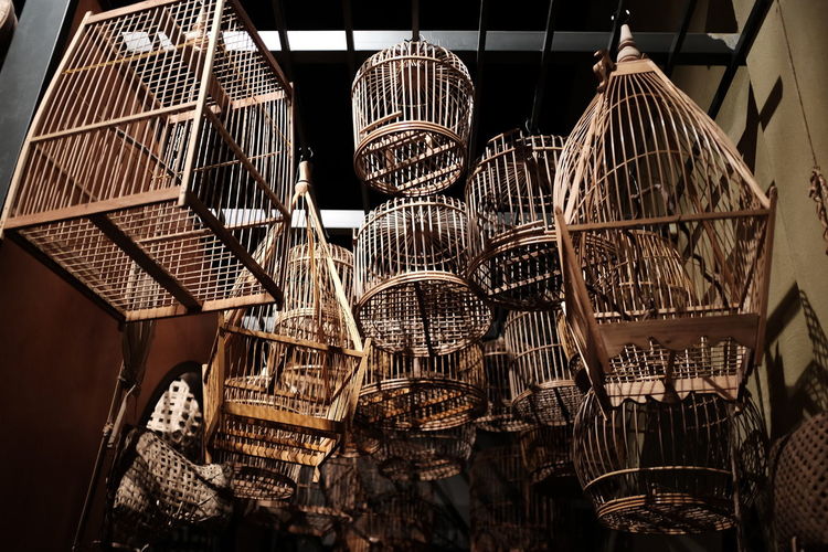 Low angle view of wooden birdcages at store for sale