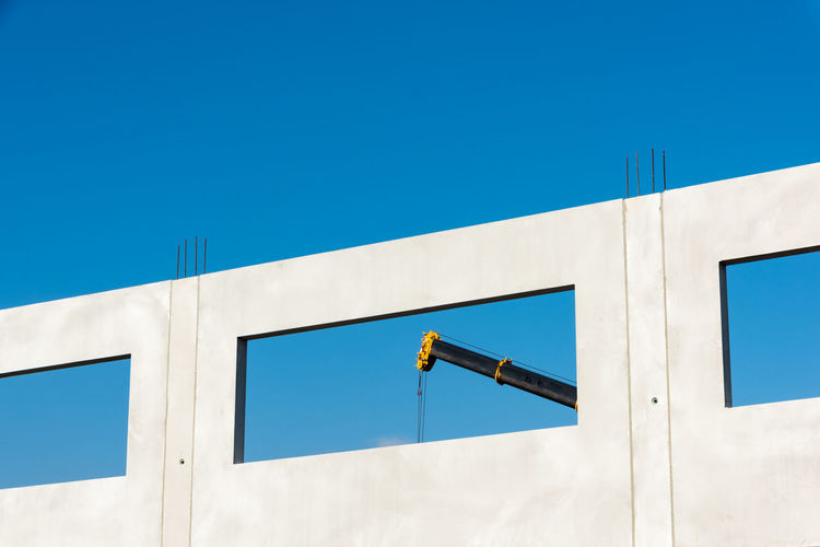 A crane at work behind a window of the modular building