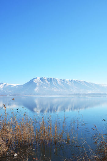 Winter landscape scene with frozen lake, snowy mountain