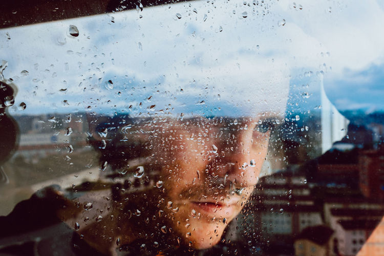 Depressed man looking through window