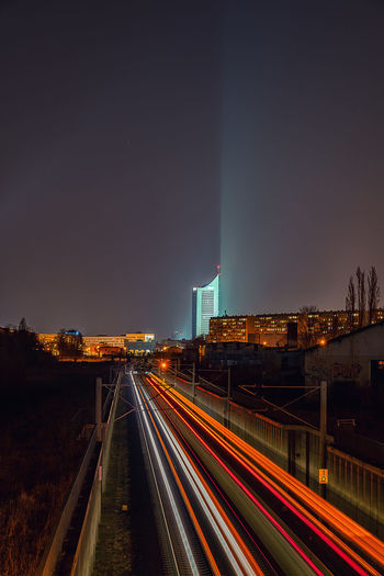 Light trails on road against sky at night