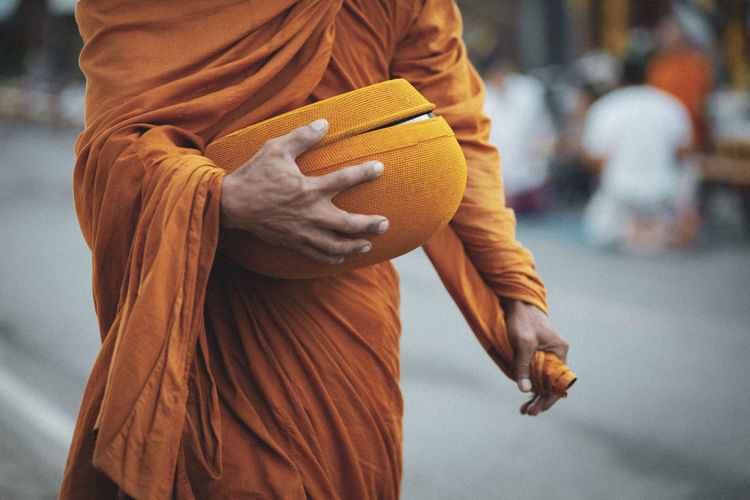 Thai buddha monk holding buddhist bowl for receiving morning food offering