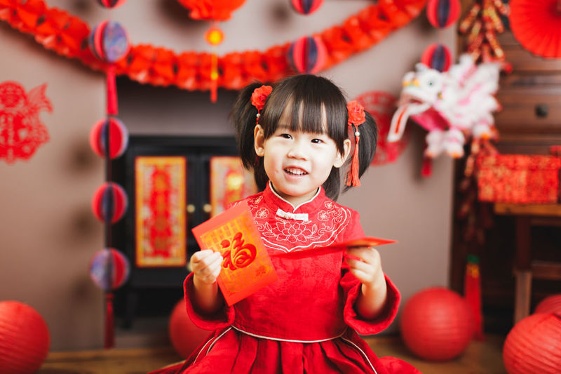 Portrait of cute girl standing against decorations at home