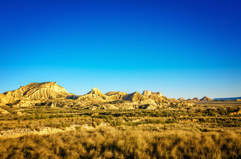 Scenic view of bardenas reales, spain. desert landscape against clear blue sky