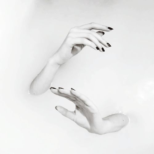 Cropped image of woman hands coming out from water
