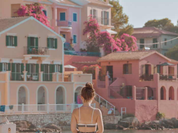 Rear view of woman standing against buildings