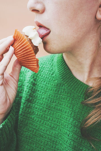 Woman licking icing on cupcake